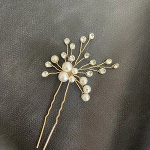 Detail of handcrafted bridal U-shaped hair pin with white pearls and sparkling rhinestones