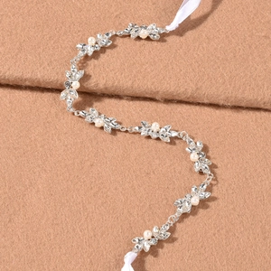 Détail d'un bandeau de mariée avec strass scintillants et perles sur tissu moelleux