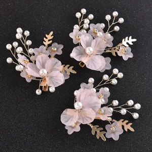 Dettaglio di fermagli sposa floreali rosa con perle, foglie dorate e strass