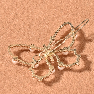 Barrette papillon dorée élégante ornée de perles sur un fond en feutre de qualité
