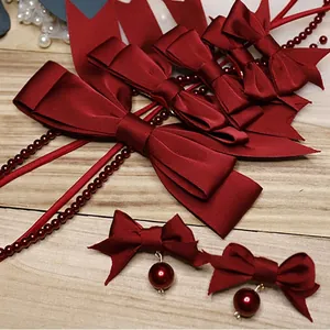 Close-up of wine red satin bow hair accessories and matching beaded earrings set