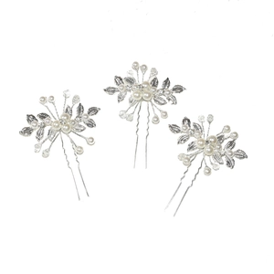 Detail view of three silver-plated U-shaped bridal hair pins with pearls and crystals