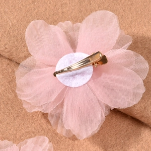 Detailed close-up of pink mesh flower hair clips with gold metal duckbill clips