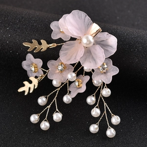 Dettaglio del fermaglio per capelli da sposa con fiori in resina rosa, perle e nappe