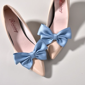 Close-up of elegant light blue satin multi-layered bow decoration on a pointed flat shoe