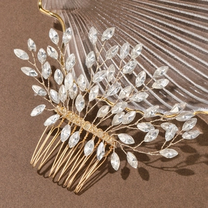 Détail macro d'un peigne à cheveux de mariée avec fils dorés et cristaux marquise en verre