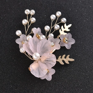 Dettaglio di fermaglio per capelli a fiore rosa smerigliato con perle e foglie d'oro