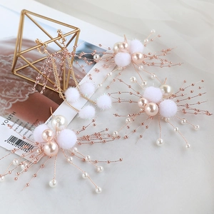 Braut Haarschmuck Set mit weißen Pompons Perlen und Goldkette auf Marmorplatte