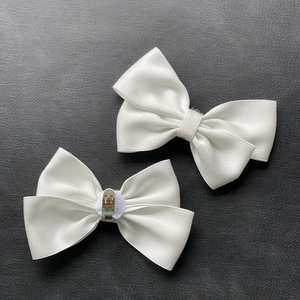 Detailed back and front view of white satin bow shoe clips with silver metal buckles