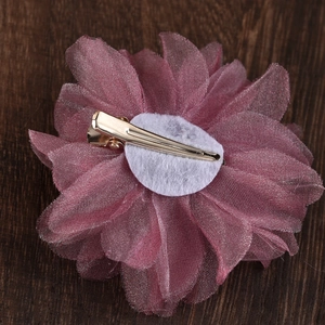 Close-up showing the golden metal clip and felt base of the dusty rose fabric flower hair clip