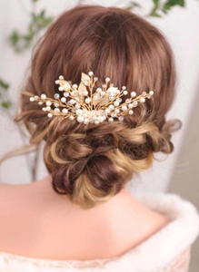 Detailed back view of bridal hair comb with gold leaves and white pearls on model