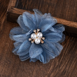 Detailed macro view of blue mesh flower accessory with elegant pearls and rhinestones