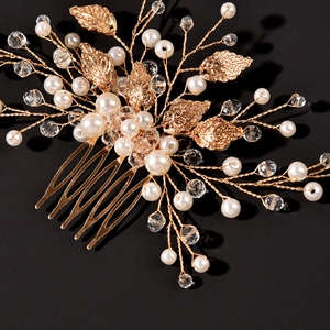 Detailed close-up of bridal hair comb featuring golden leaves, pearls and crystals