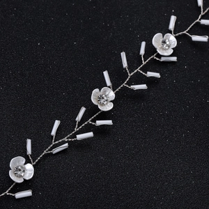 Détail d'un bandeau de mariée fait main avec pétales en céramique et perles en cristal fin