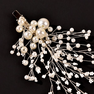 Vue macro d'une barrette de mariée faite main avec perles blanches et fil argenté