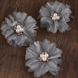 Detailed macro view of grey mesh flower hair clips with central pearls and crystals