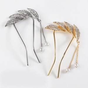 Close-up of gold and silver leaf hair pins with sparkling rhinestones and pearl tassels