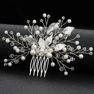 Macro detail of bridal hair comb with silver leaves, white pearls and crystal beads