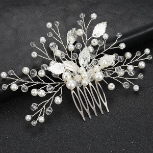 Detailed close-up of handmade bridal hair comb with silver leaves, pearls and crystals