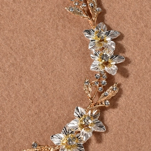 Vue macro d'un accessoire cheveux mariée avec fleurs dorées et zircons brillants
