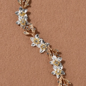 Détails de vigne de cheveux de mariée avec fleurs argentées et cristaux dorés brillants