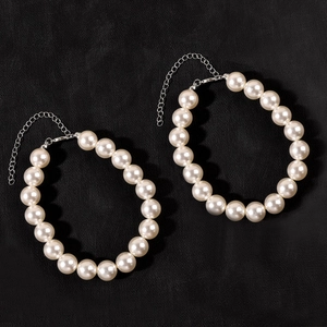 Detail of two white pearl anklets with silver lobster clasps and extension chains