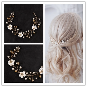 Detail of bridal hair vine with white flowers, pearls, and crystals on gold wire