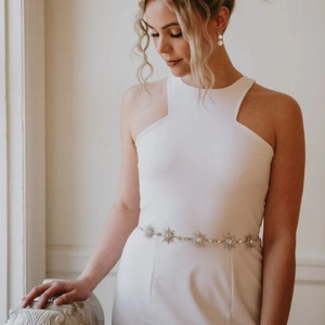 Elegant bridal wedding belt with silver star-shaped rhinestones on a white dress