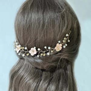 Detailed back view of a gold wire bridal headpiece with pink flowers and pearls
