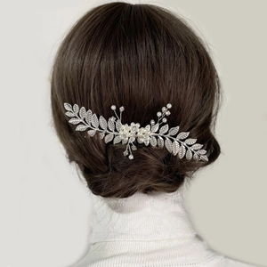 Peigne à cheveux argenté avec feuilles et perles sur une coiffure de mariée élégante