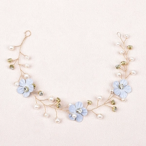 Detail of bridal hair vine with blue fabric flowers, pearls, and gold wire rhinestones