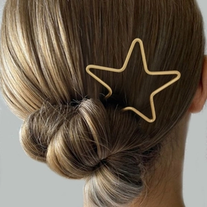 Épingle à cheveux dorée en forme d'étoile minimaliste portée sur un chignon élégant
