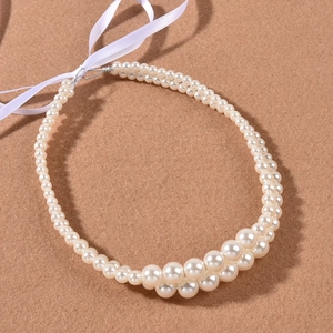 Detailed macro view of woven double-row pearl bridal hairband with elegant white ribbons