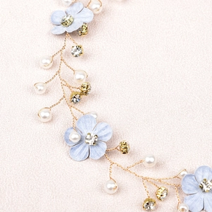 Close-up of handmade bridal hair vine with light blue flowers and white pearls