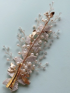 Macro detail of handmade bridal headpiece with white beads, pearls and gold wire