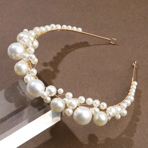 Detail of vintage bridal headband featuring white pearls and delicate gold wire wrap