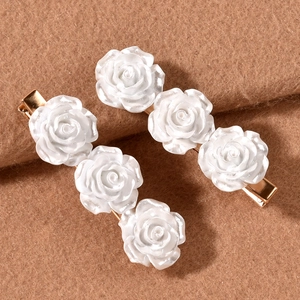 Elegant pair of white resin camellia hair clips with golden metal frames and 3D roses
