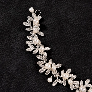 Detail shot of a silver bridal hair vine with shimmering rhinestones and white pearls