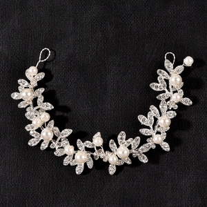Detailed close-up of a silver bridal hair vine with sparkling crystals and white pearls