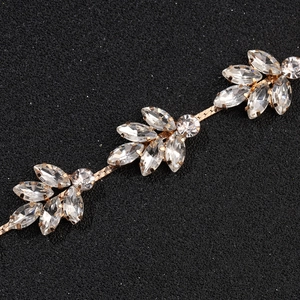 Détail macro du peigne de mariée avec fleurs dorées et strass de marquise étincelants