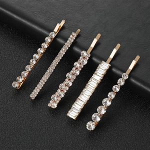 Détail d'un lot de cinq barrettes à cheveux en métal doré avec strass brillants