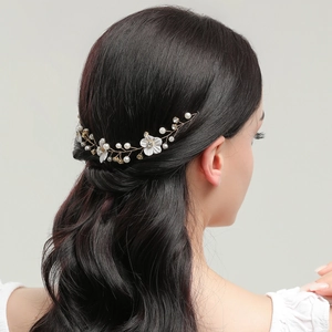 Elegant bridal hair vine with white flowers, pearls and crystals on gold wire for weddings