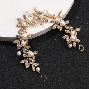 Close-up of golden bridal hair vine with crystal leaves and white pearls for wedding styles