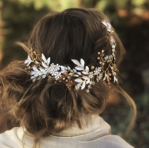 Detail of bridal hair vine with golden leaves and crystals on soft brown hair