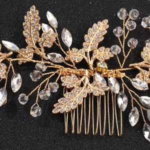 Close-up of golden bridal hair comb with crystal flowers and metal leaves detail