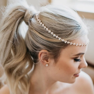 Detailed side view of rose gold bridal hair chain with crystal flower clusters on model