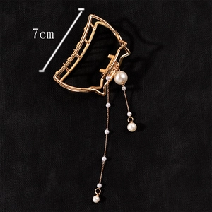 Detailed macro view of 7cm golden cat hair claw clip with elegant pearl tassels