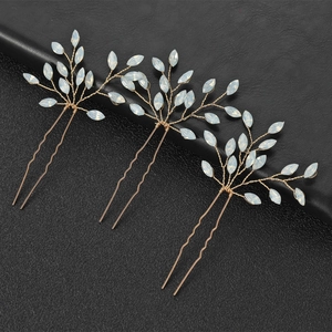 Detailed macro view of U-shaped gold hair pins with opal marquise crystals and wire wrap