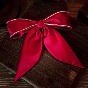 Elegant red silk bridal hair bow with white pearl trim and long ribbon tassels