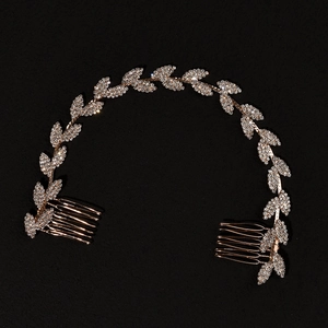 Dettaglio accessorio capelli sposa con cristalli scintillanti e foglie dorate su sfondo nero